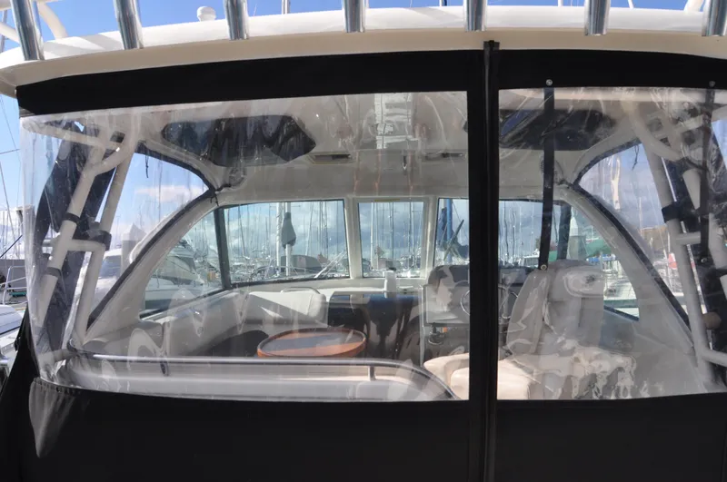 Slide: The Image of 2014 Pursuit OS 315 Offshore boat interior with clear enclosure and seating. - 4