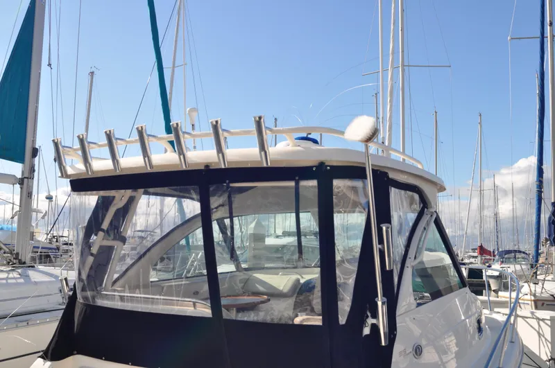 Slide: The Image of 2014 Pursuit OS 315 Offshore boat docked at marina, clear skies, sailboats in background. - 5