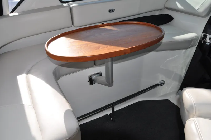 Slide: The Image of 2014 Pursuit OS 315 Offshore interior with wooden table and cushioned seating. - 7