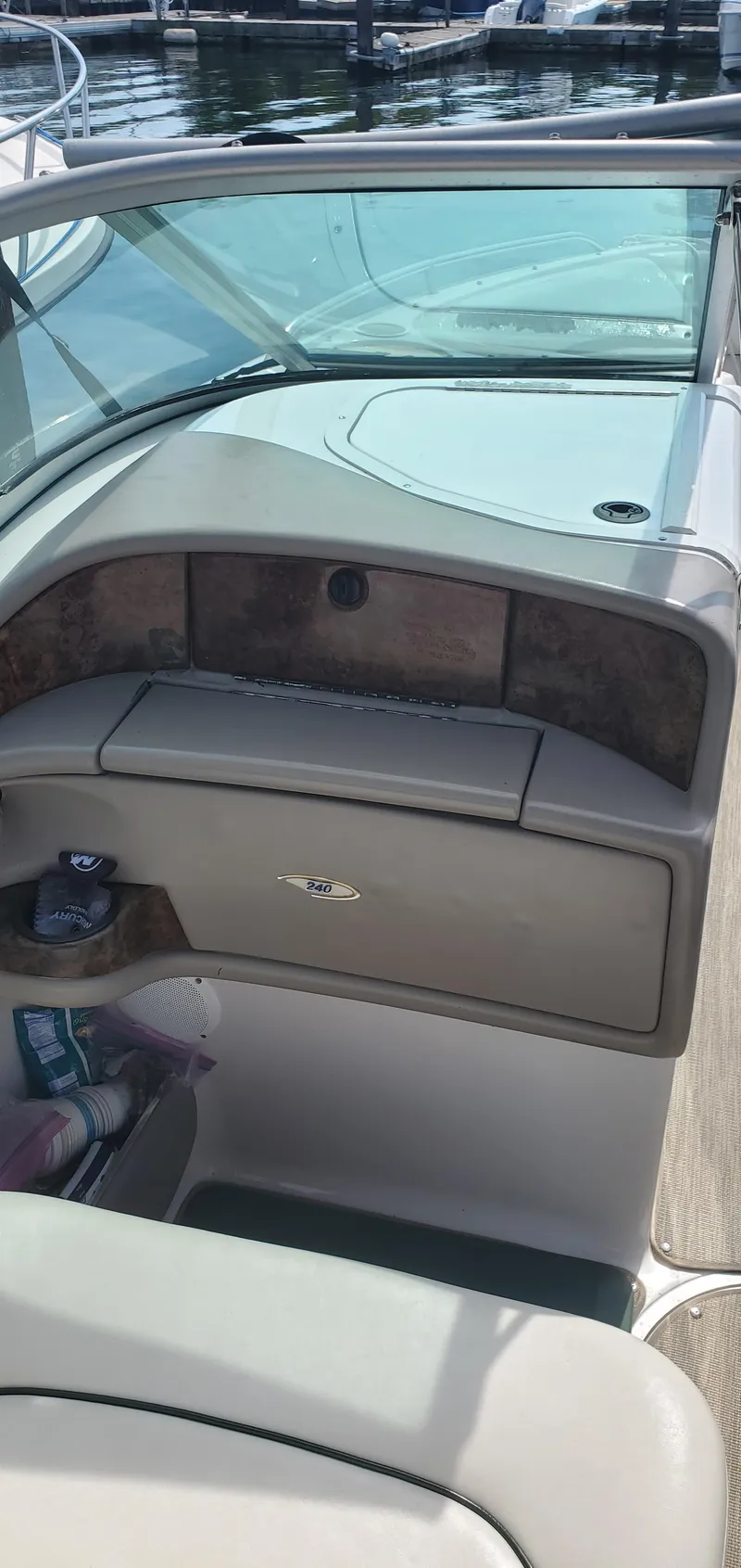 Slide: The Image of 2002 Four Winns 240 Horizon boat interior with dashboard and storage compartment. - 10