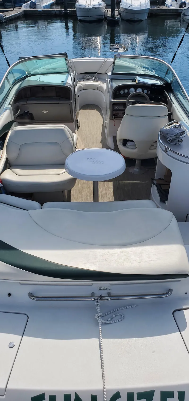 Slide: The Image of 2002 Four Winns 240 Horizon boat interior with seating and table, docked at marina. - 16