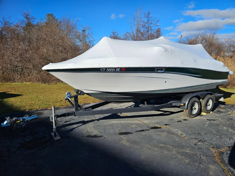 Slide: The Image of 2002 Four Winns 240 Horizon boat on trailer, covered, parked outdoors. - 17
