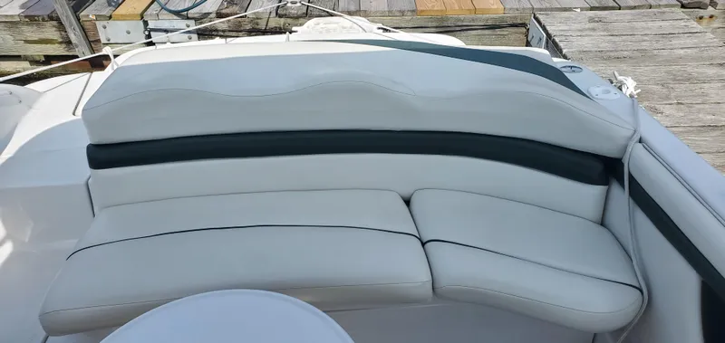 Slide: The Image of 2002 Four Winns 240 Horizon boat interior with white cushioned seating. - 2