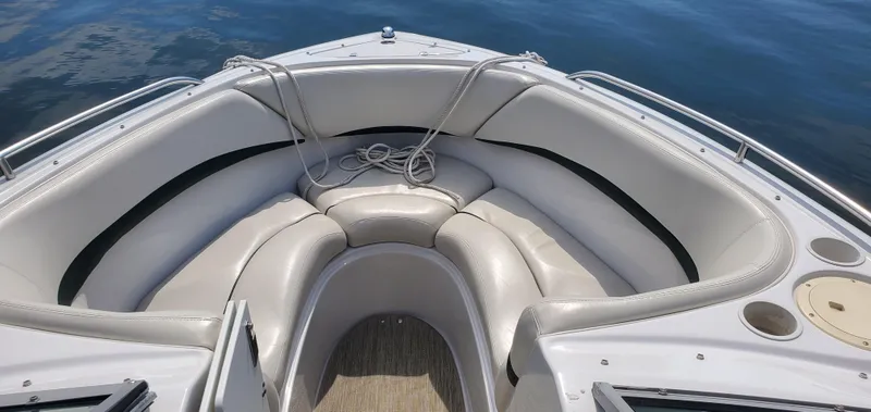 Slide: The Image of 2002 Four Winns 240 Horizon boat with white cushioned seating and rope on deck. - 5