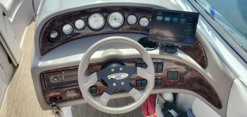 Slide: The Image of 2002 Four Winns 240 Horizon boat dashboard with steering wheel and gauges. - 9