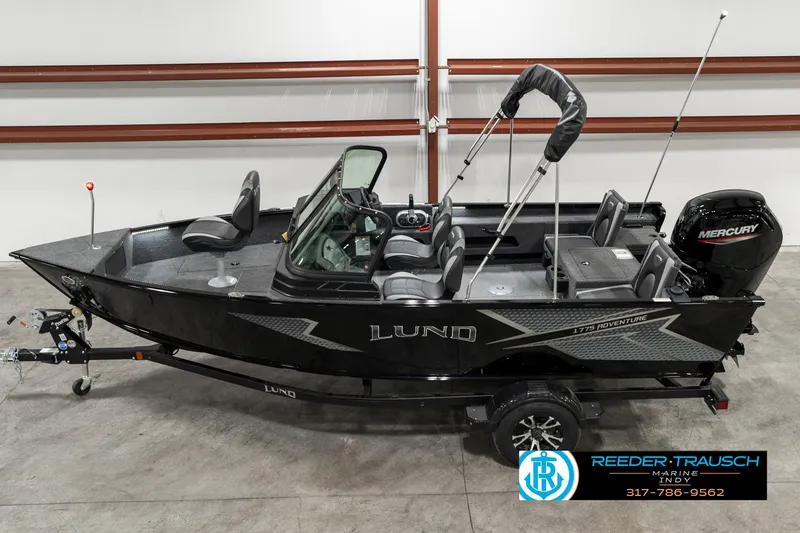 Slide: The Image of 2025 Lund 1775 Adventure Sport boat with Mercury engine, displayed indoors on a trailer. - 1