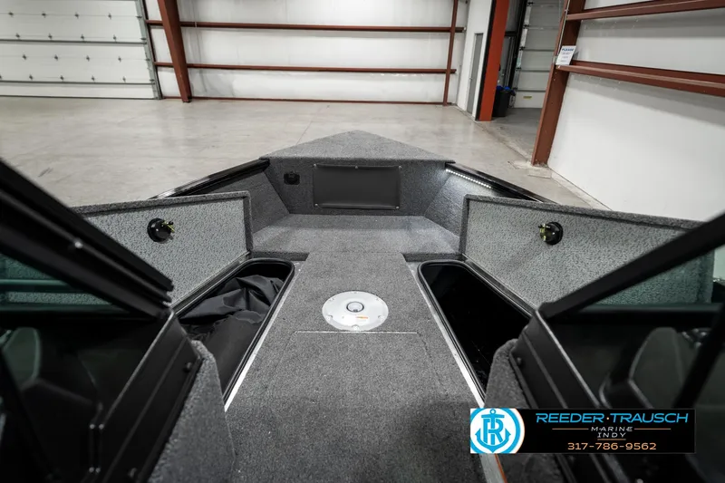 Slide: The Image of 2025 Lund 1775 Adventure Sport boat interior with open storage compartments in a garage. - 19