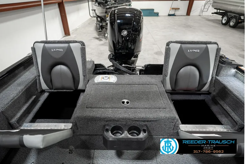 Slide: The Image of 2025 Lund 1775 Adventure Sport boat interior with seating and motor, displayed in showroom. - 25