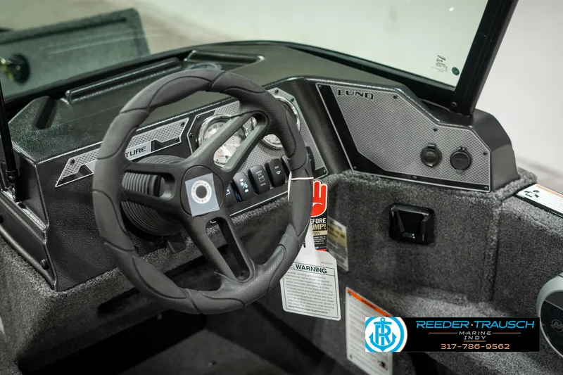 Slide: The Image of 2025 Lund 1775 Adventure Sport boat dashboard with steering wheel and controls. - 29