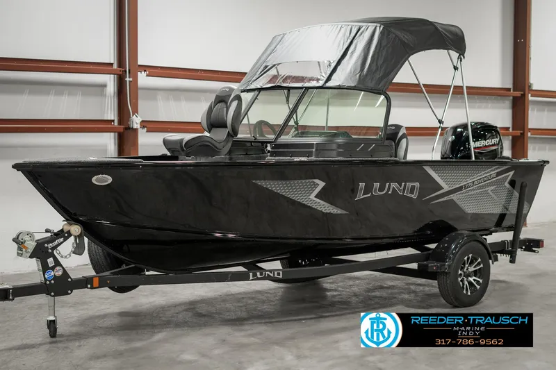 Slide: The Image of 2025 Lund 1775 Adventure Sport boat in showroom, black exterior, on trailer. - 3