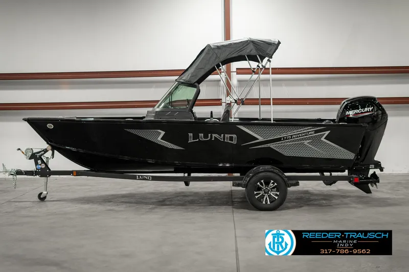 Slide: The Image of 2025 Lund 1775 Adventure Sport boat in showroom, black exterior, on trailer. - 4