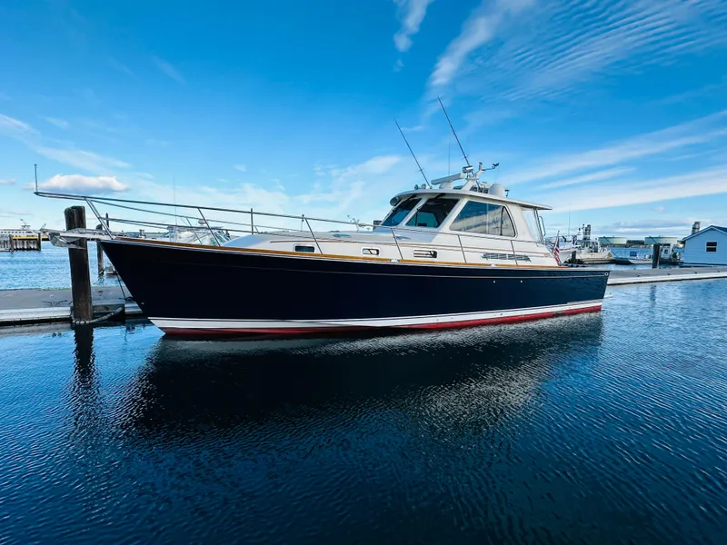 Slide: The Image of 2009 Sabre 42 Hardtop Express yacht docked on calm water under blue sky. - 0