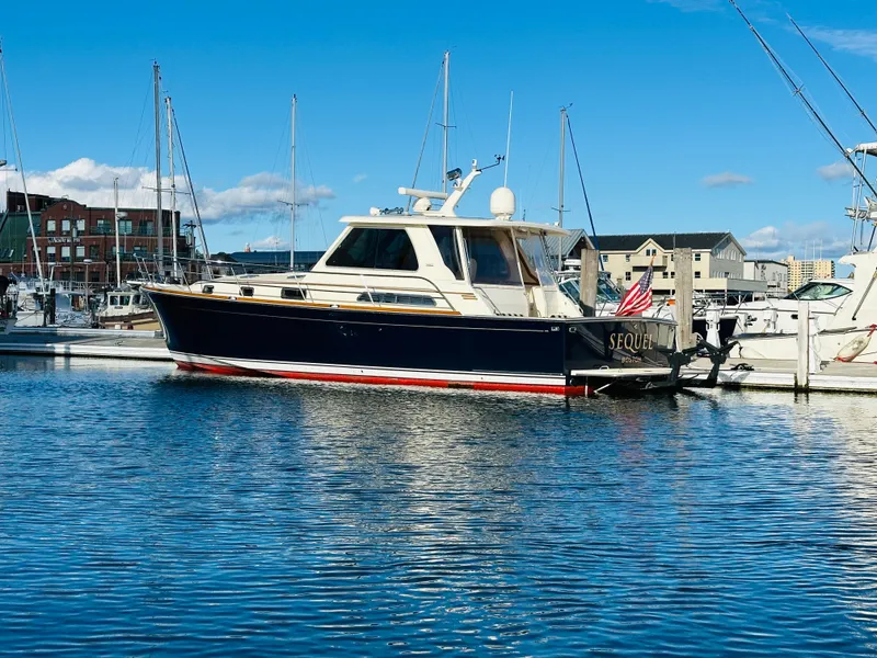 Slide: The Image of 2009 Sabre 42 Hardtop Express yacht docked in marina under clear blue sky. - 1