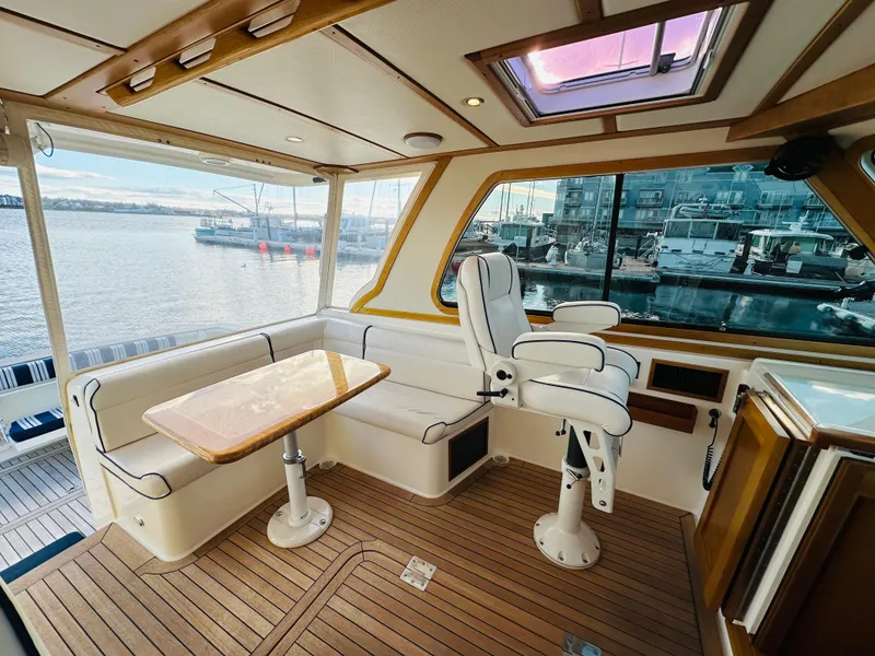 Slide: The Image of 2009 Sabre 42 Hardtop Express interior with seating, table, and waterfront view. - 12