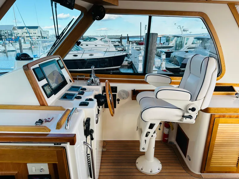Slide: The Image of 2009 Sabre 42 Hardtop Express helm with modern controls and marina view. - 14