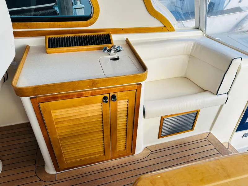 Slide: The Image of 2009 Sabre 42 Hardtop Express interior with wood cabinetry and cushioned seating. - 16