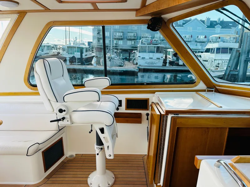 Slide: The Image of Interior of 2009 Sabre 42 Hardtop Express with white captain's chair and wooden accents. - 23