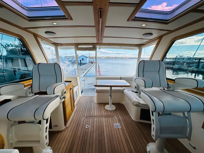 Slide: The Image of 2009 Sabre 42 Hardtop Express interior with plush seating and scenic marina view. - 24