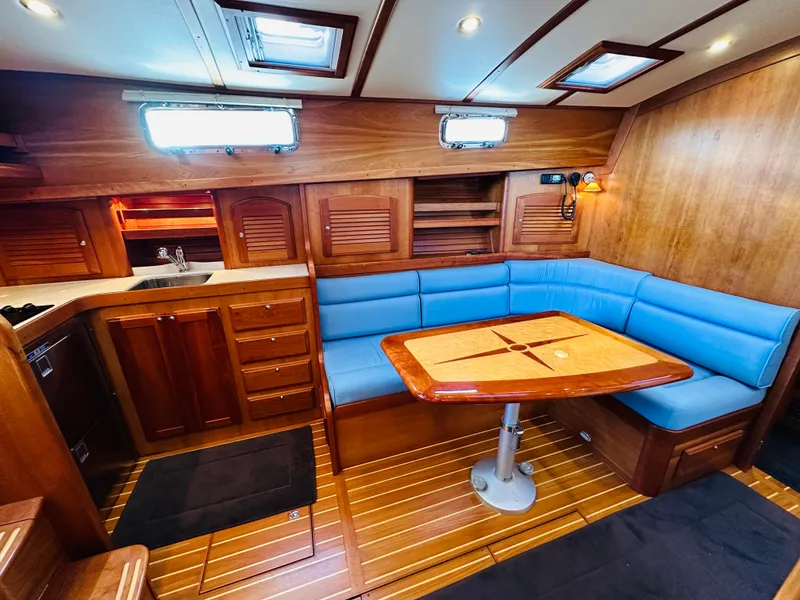 Slide: The Image of 2009 Sabre 42 Hardtop Express interior with blue seating and wooden table. - 26