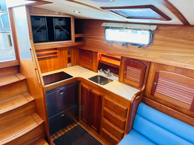 Slide: The Image of 2009 Sabre 42 Hardtop Express yacht interior with wooden cabinetry and compact kitchen. - 27
