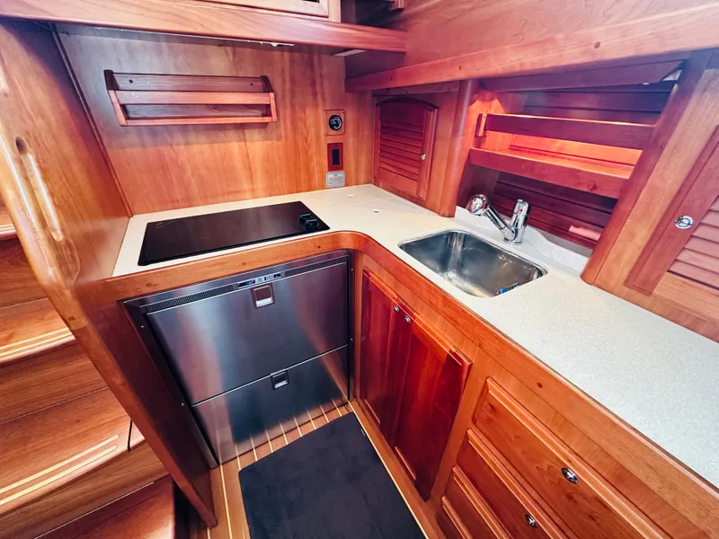 Slide: The Image of 2009 Sabre 42 Hardtop Express yacht kitchen with wood cabinetry and modern appliances. - 28