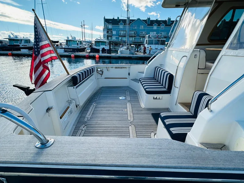 Slide: The Image of 2009 Sabre 42 Hardtop Express yacht with striped seating, docked in a marina. - 3