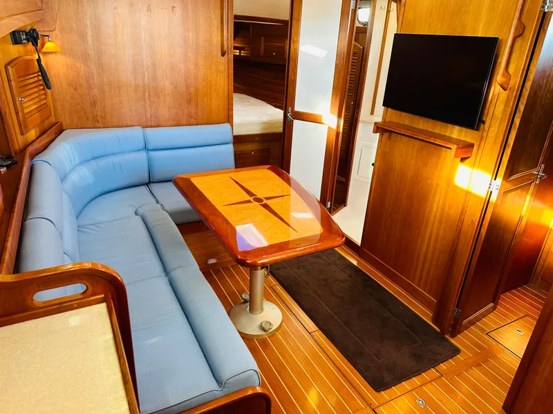 Slide: The Image of 2009 Sabre 42 Hardtop Express interior with blue seating, wooden table, and TV. - 31