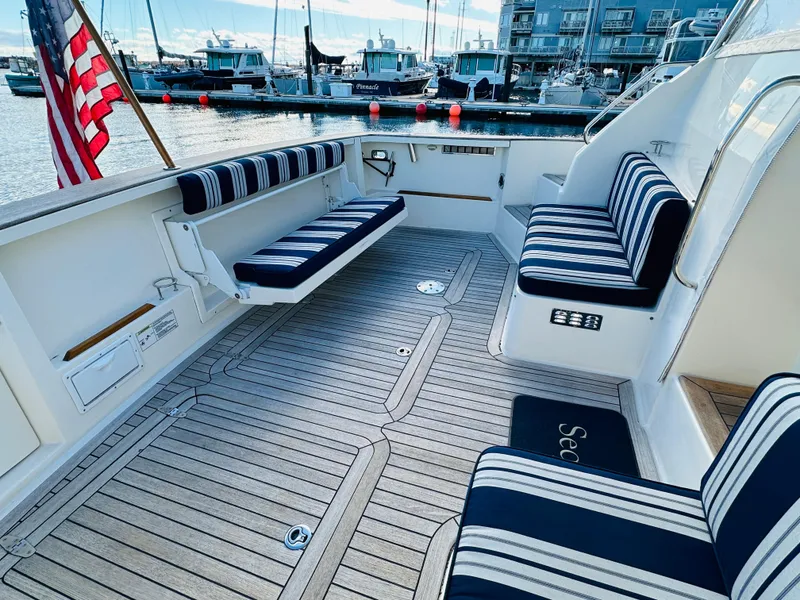 Slide: The Image of 2009 Sabre 42 Hardtop Express boat with striped seating in a marina setting. - 4