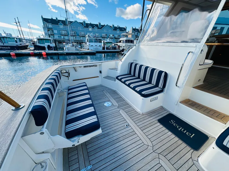 Slide: The Image of 2009 Sabre 42 Hardtop Express yacht with striped seating at a marina. - 5