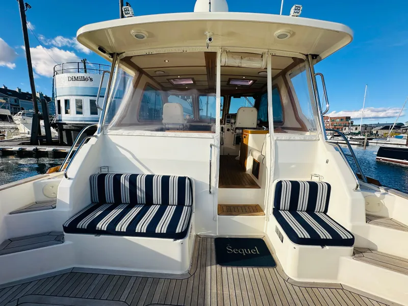 Slide: The Image of 2009 Sabre 42 Hardtop Express yacht with striped seating at marina. - 6