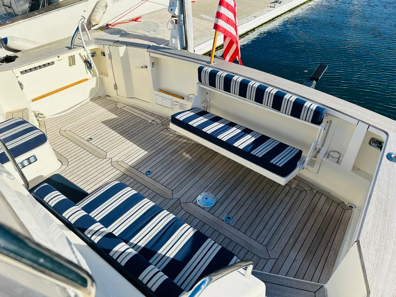 Slide: The Image of 2009 Sabre 42 Hardtop Express boat deck with striped seating and American flag. - 7