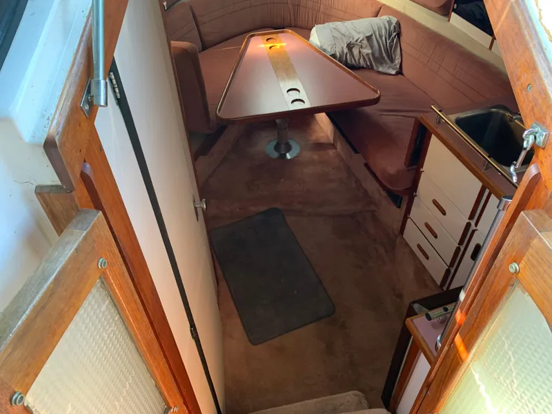 Slide: The Image of Interior of 1986 Carver 28 Riviera boat with cozy seating and wooden table. - 10