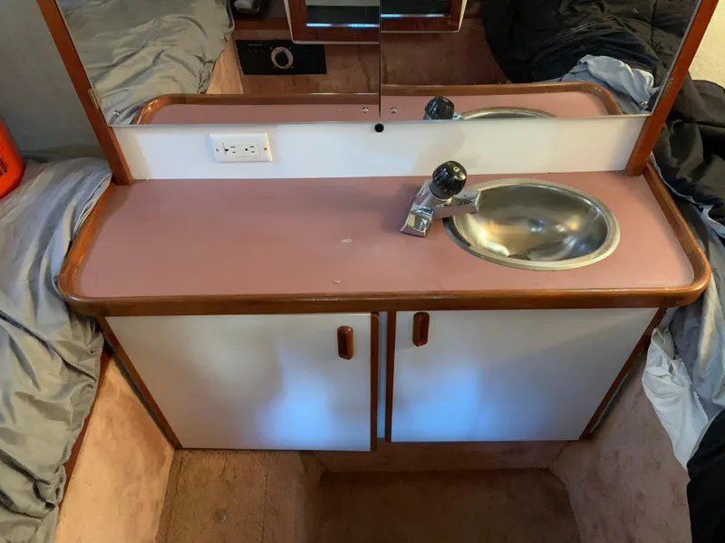 Slide: The Image of 1986 Carver 28 Riviera cabin sink with mirror and storage cabinets. - 9