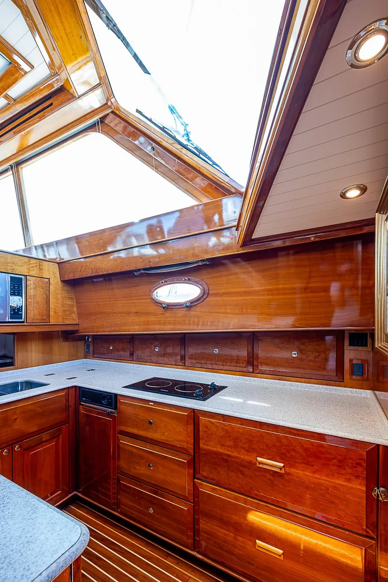Slide: The Image of Luxurious 2005 Hinckley Talaria 55 MY yacht kitchen with wood cabinetry and skylight. - 17