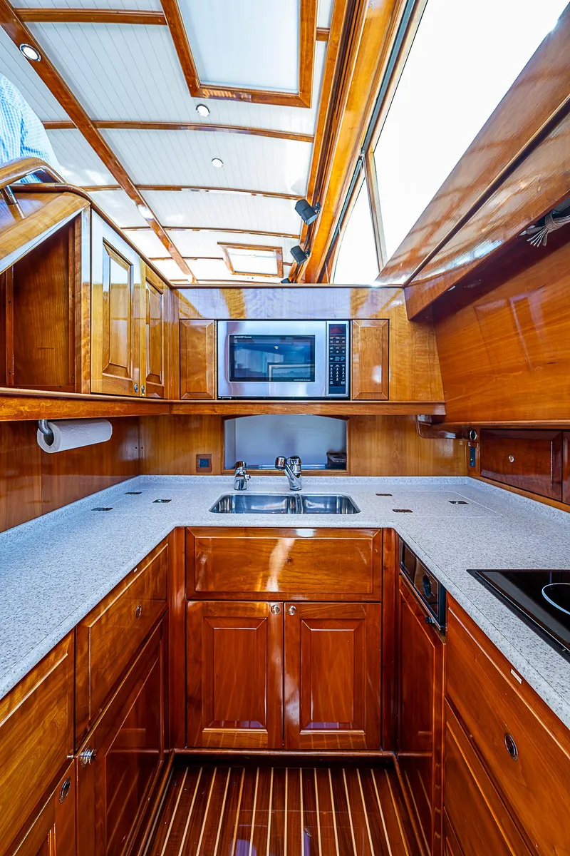 Slide: The Image of Luxurious 2005 Hinckley Talaria 55 MY yacht kitchen with wood cabinetry and modern appliances. - 18