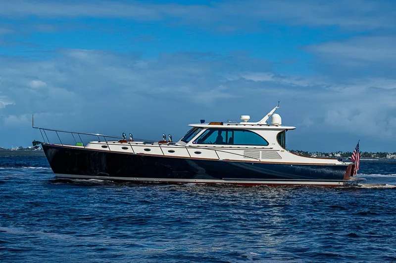 Slide: The Image of 2005 Hinckley Talaria 55 MY yacht cruising on open water under a clear blue sky. - 2