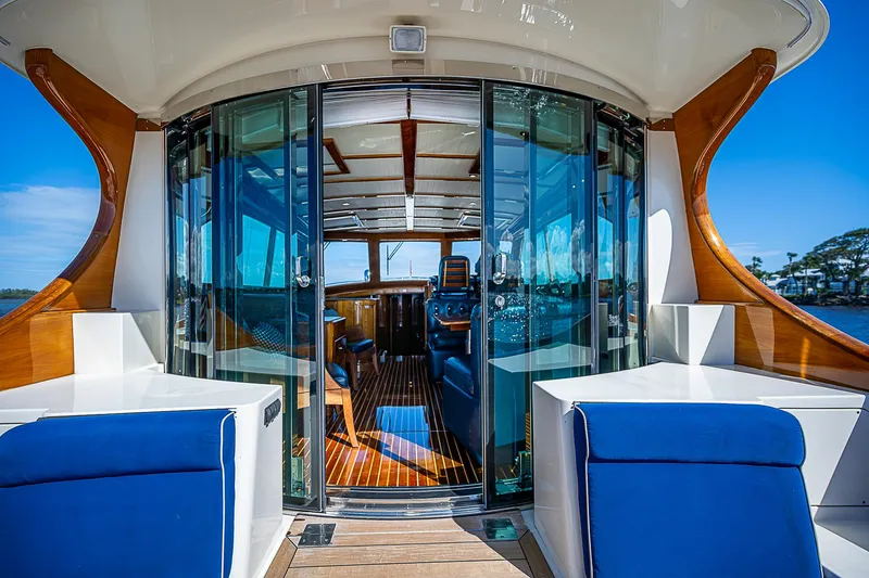 Slide: The Image of Luxurious 2005 Hinckley Talaria 55 MY yacht interior with blue seating and glass doors. - 6