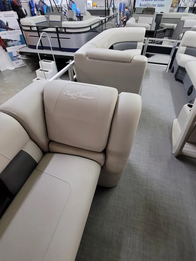 Slide: The Image of 2025 SunChaser Vista 22 Fish pontoon boat with beige seating in showroom. - 12