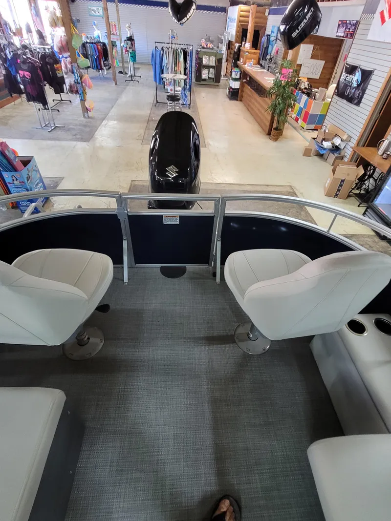 Slide: The Image of 2025 SunChaser Vista 22 Fish boat interior with seating, displayed in a showroom. - 14
