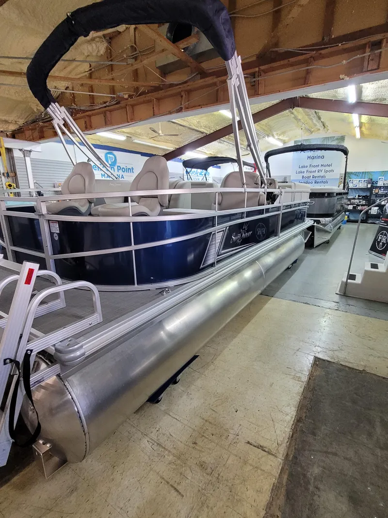 Slide: The Image of 2025 SunChaser Vista 22 Fish pontoon boat in showroom, featuring sleek design and comfortable seating. - 2