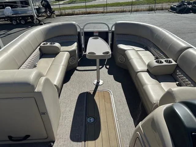 Slide: The Image of 2021 Ranger RP243C pontoon boat interior with beige seating and table. - 10