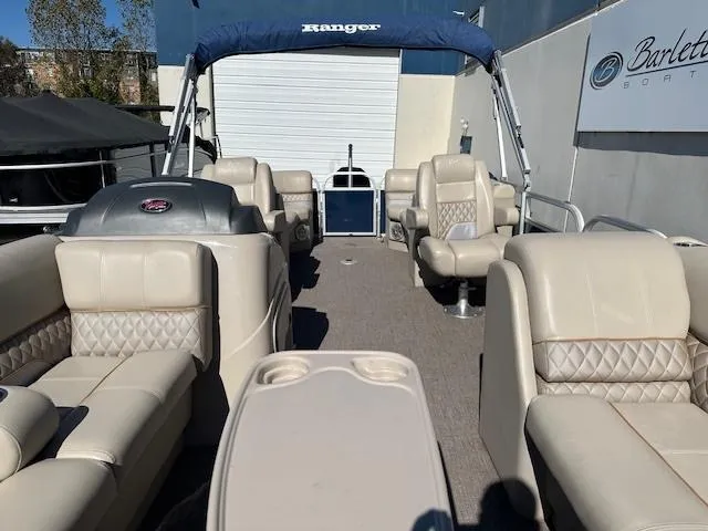 Slide: The Image of 2021 Ranger RP243C pontoon boat with beige seating and blue canopy. - 5