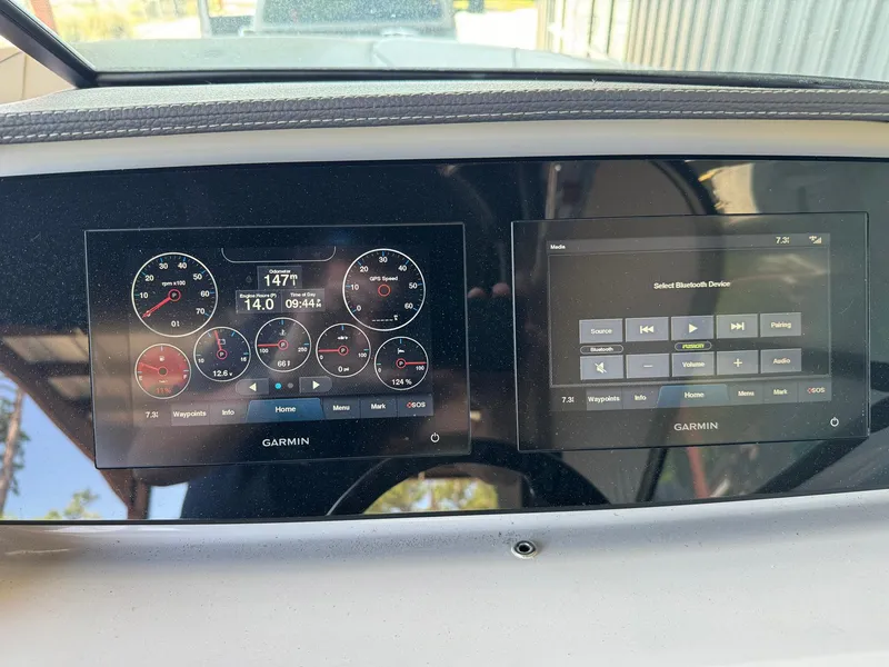 Slide: The Image of Dashboard of a 2022 Regal LX2 boat with Garmin displays showing gauges and controls. - 15