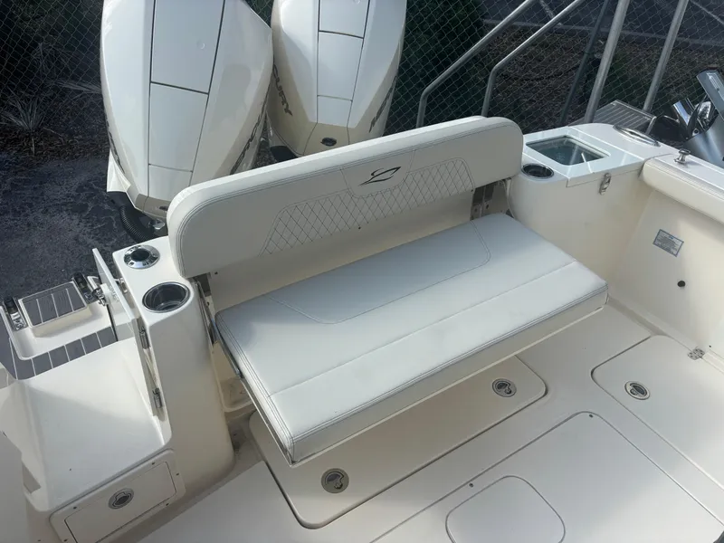 Slide: The Image of 2025 Scout 277 LXF boat seating area with dual engines and cup holders. - 11