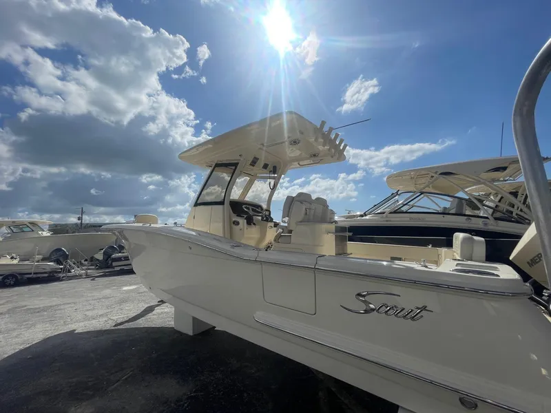 Slide: The Image of 2025 Scout 277 LXF boat under sunny sky at marina. - 2