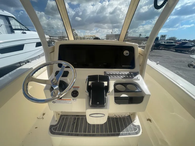 Slide: The Image of 2025 Scout 277 LXF boat helm with steering wheel and control panel. - 3