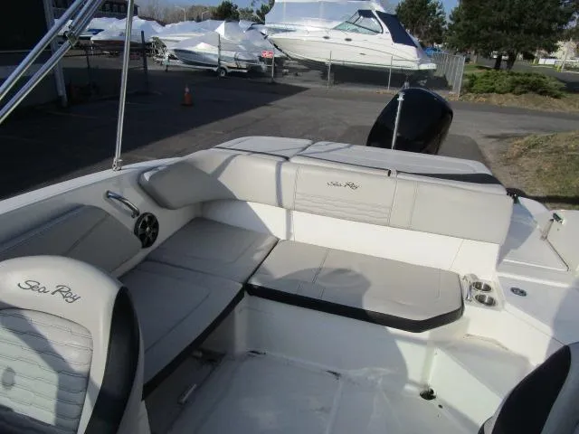 Slide: The Image of 2021 Sea Ray 210 SPX boat interior with cushioned seating and sleek design. - 12