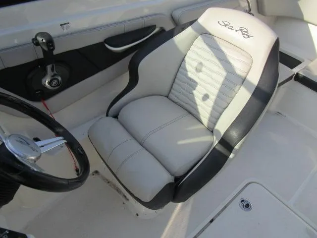Slide: The Image of 2021 Sea Ray 210 SPX boat interior with steering wheel and cushioned seat. - 7