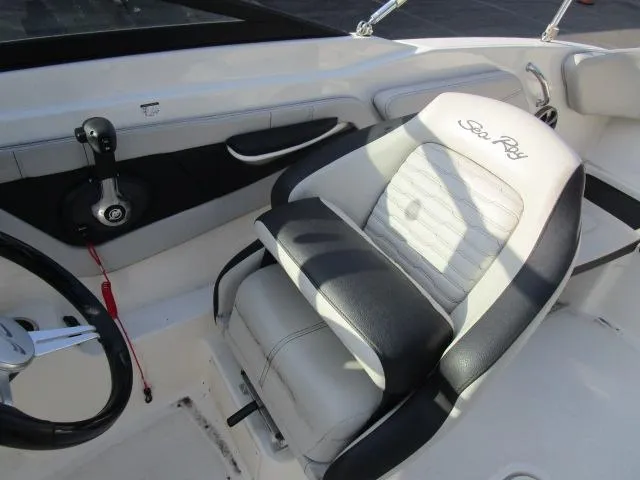 Slide: The Image of 2021 Sea Ray 210 SPX boat interior with steering wheel and branded seat. - 9