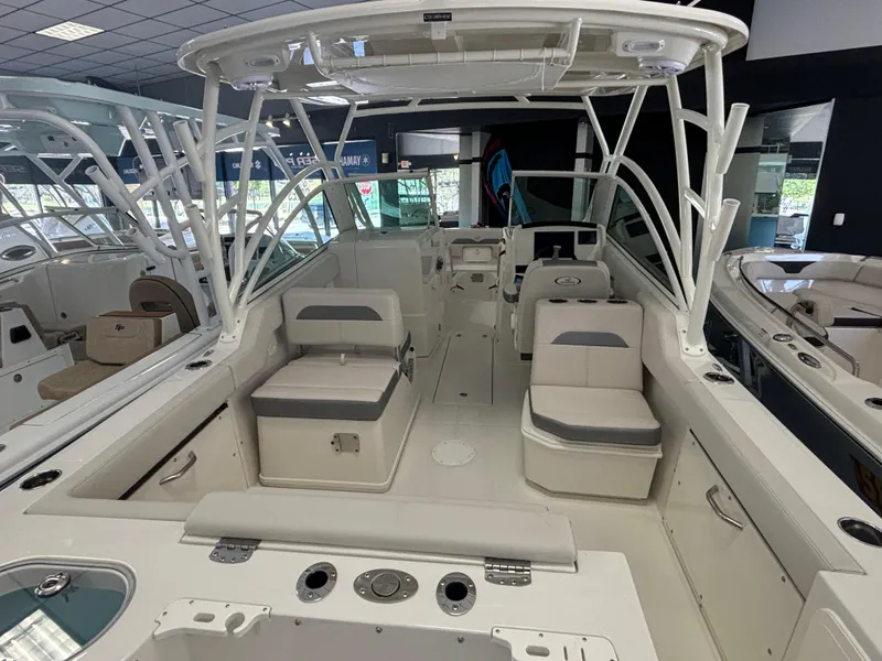 Slide: The Image of 2025 Sailfish 245 DC boat interior with seating and helm in showroom. - 4
